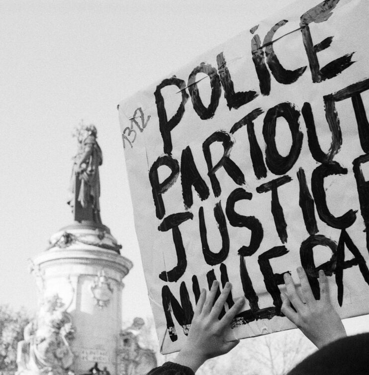 Sign lifted with a strong message, police everywhere justice nowhere, and in the background the status of the Republic Square. Paris, France, 28th november 2020. Photography by Lou Osra / Hans Lucas.
Pancarte levee avec un message fort, police partout justice nulle part, et en second plan la statut de la place de la Republique. Paris, France, 28 novembre 2020. Photographie par Lou Osra / Hans Lucas.